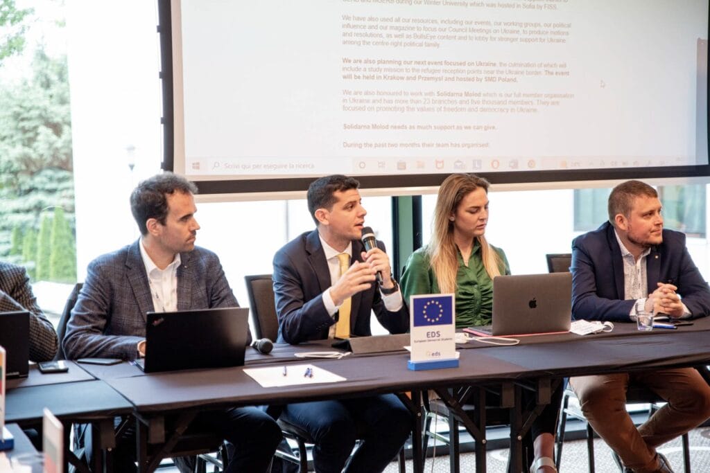 Zdjęcie ukazujące panelistów, w tle informacje wyświetlane na rzutniku