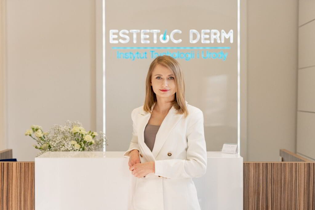 Kobieta pozująca przed logo swojej firmy do zdjęcia biznesowego