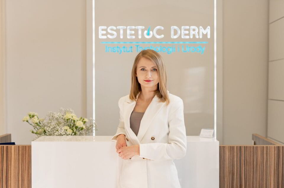 Kobieta pozująca przed logo swojej firmy do zdjęcia biznesowego