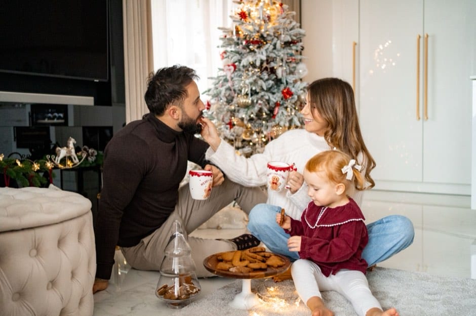 Family with gingerbread by the Christmas tree — home session