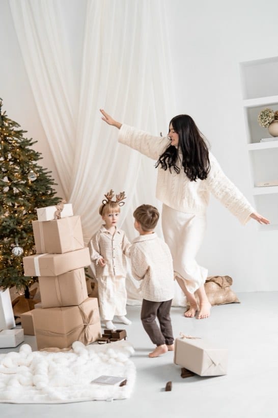 Mama z dziećmi wśród prezentów — świąteczna sesja w studio