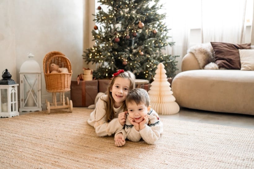 Siblings on the rug under the Christmas tree — studio session