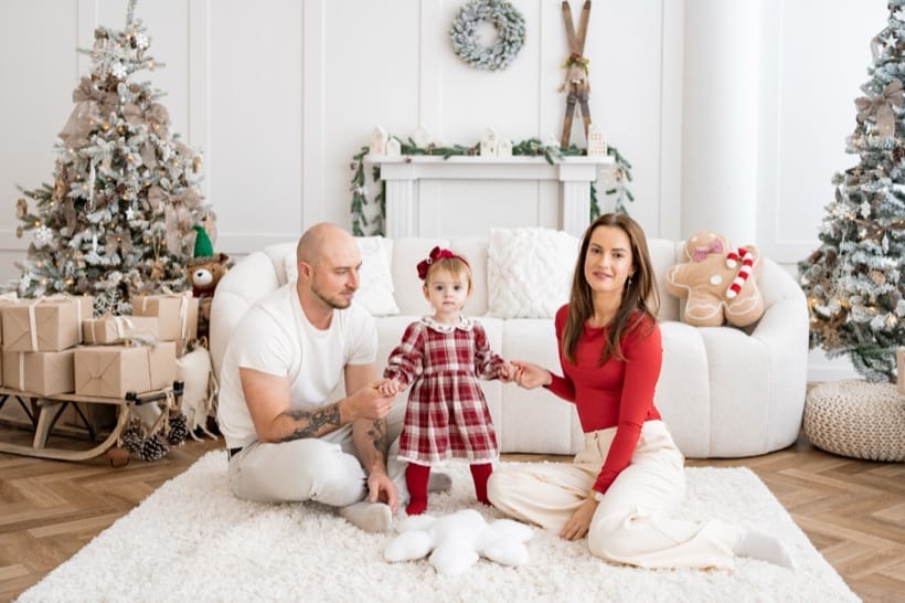 Family with their little daughter on a white rug — Christmas studio session