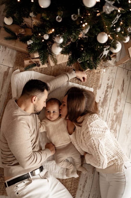 Family with their child under the Christmas tree — studio session